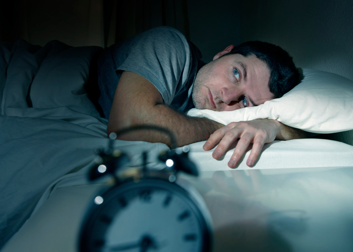 man in bed eyes opened suffering insomnia and sleep disorder