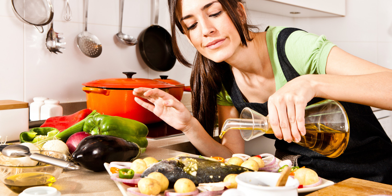 Woman pouring olive oil over fish