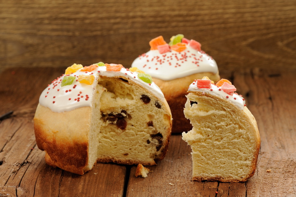 Kulich, Russian easter yeast sweet bread decorated with icing, cut,on wooden background horizontal with space