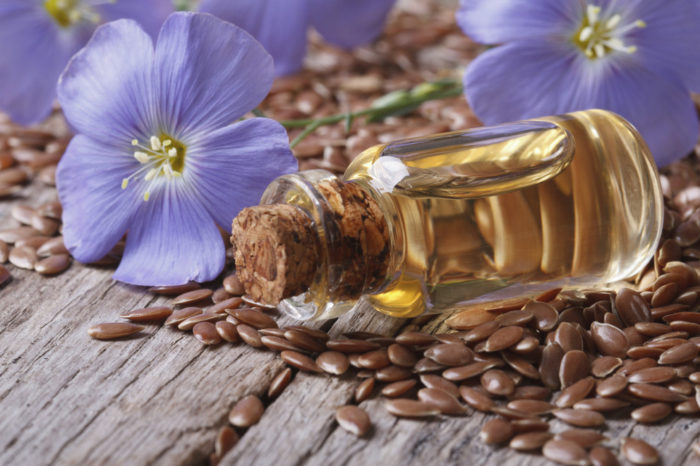 flax seeds, blue flowers and oil close-up horizontal