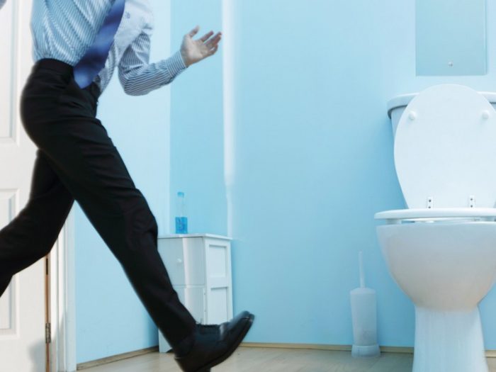 Male executive running to toilet