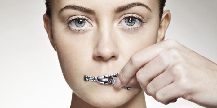 Woman zippering mouth closed