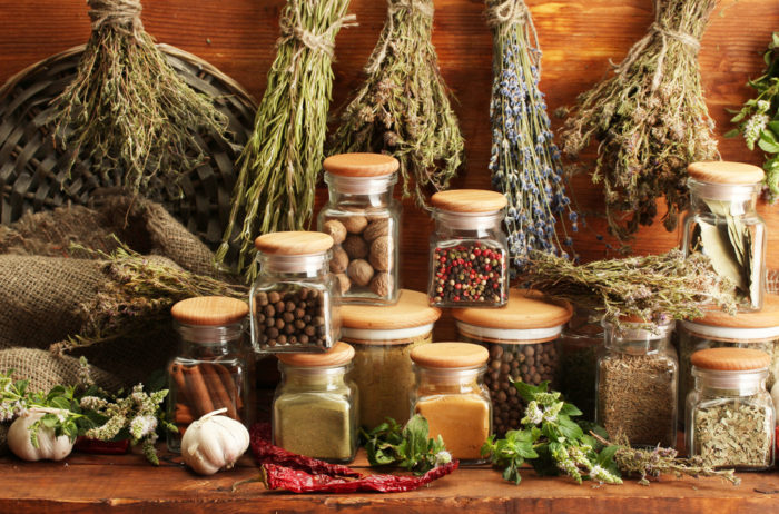 dried herbs, spices and and pepper, on wooden background