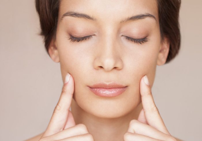 Woman massaging her face