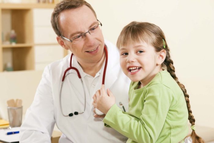 Child patient in his practice, she is examining his stethoscope, friendly and light atmosphere