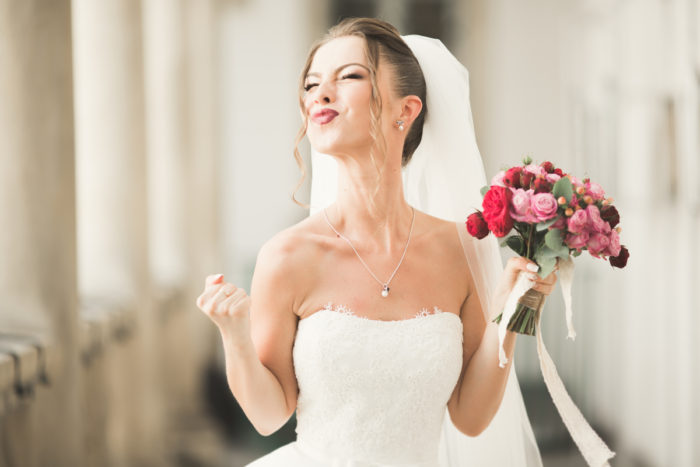 Luxury wedding bride, girl posing and smiling with bouquet.