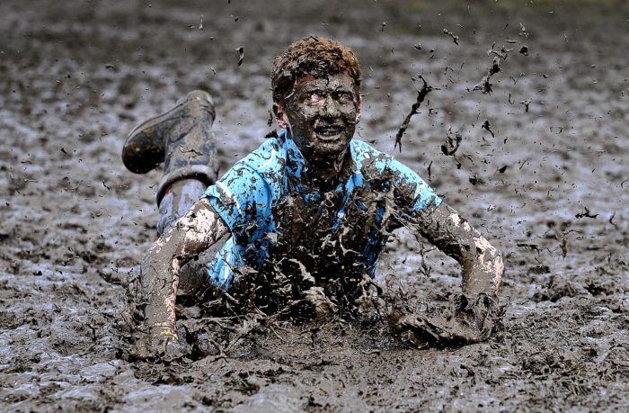 A festival-goer slides though mud. Glastonbury is known for often being held during bad weather. (Ben Birchall/Press Association)
