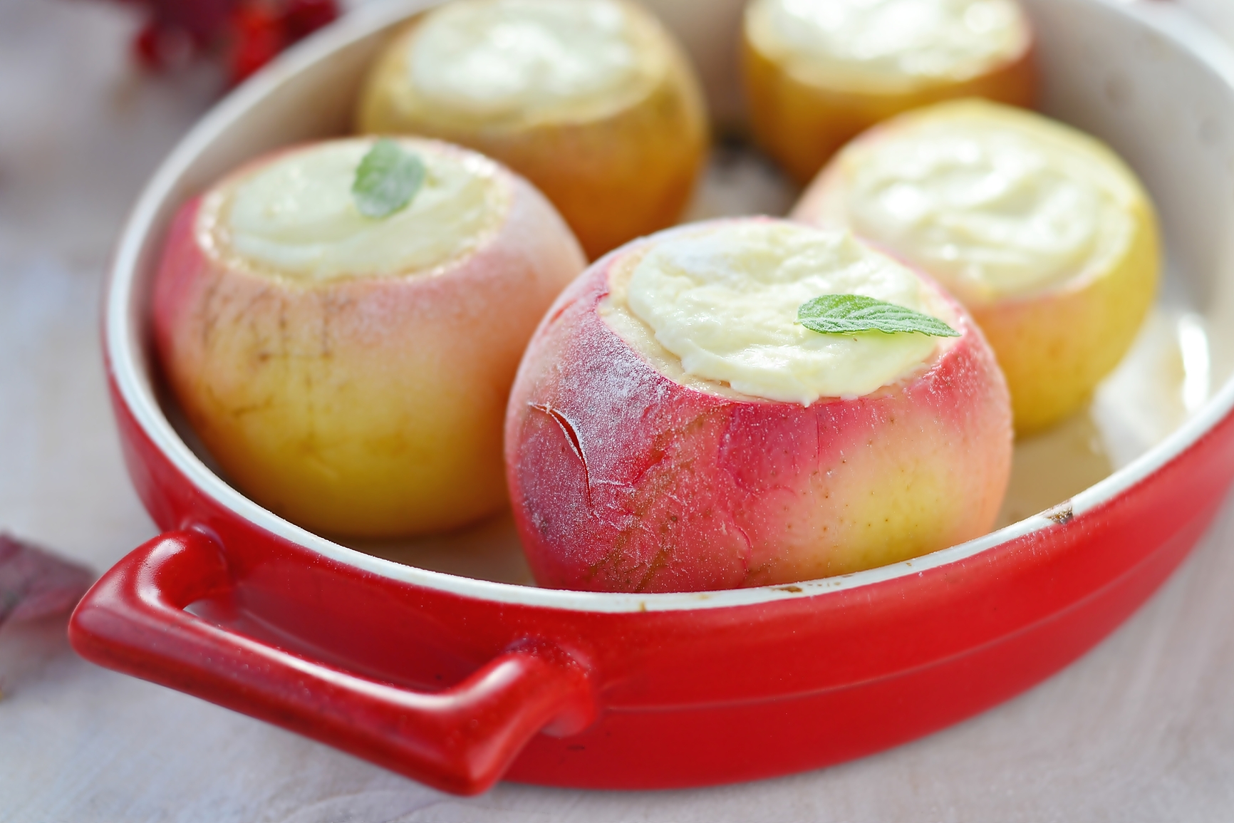Baked apples with cottage cheese on autumn background
