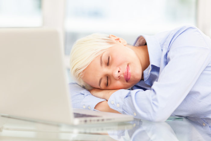 photo of exhausted businesswoman who sleeps on notebook