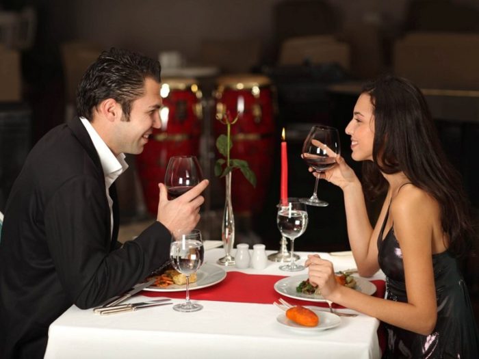 Romantic couple having dinner, smiling to each other