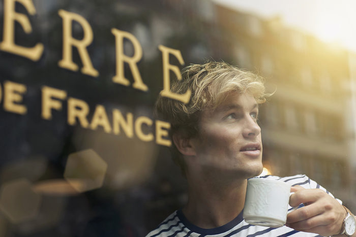 Close up of young man drinking coffee in cafe