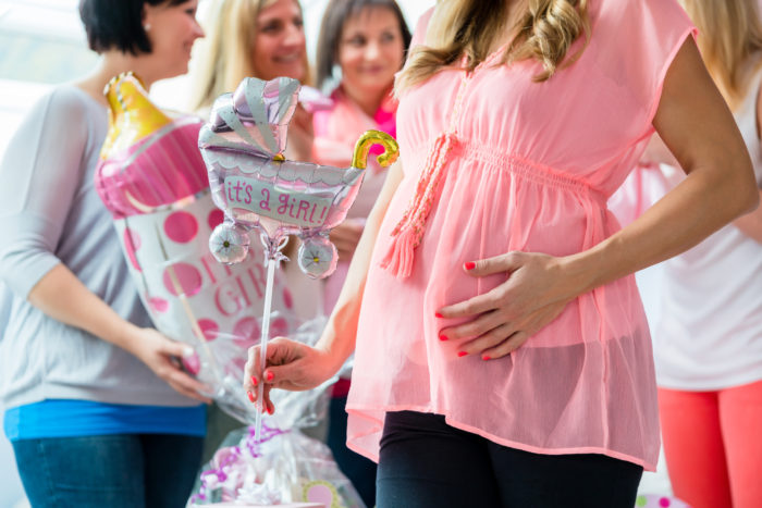 Pregnant Woman on baby shower party showing her baby belly
