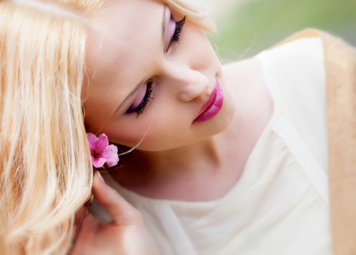 Beautiful blond girl in blossom garden