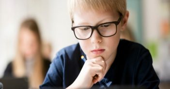 Boy concentrating on learning in classroom