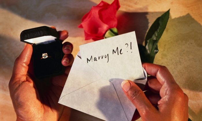 Hands Holding Box with Engagement Ring and Marry Me? Card