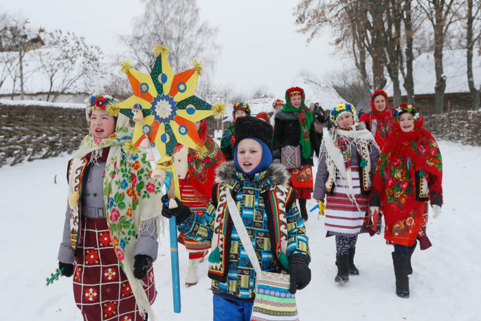 Children dressed in traditional costumes gather to celebrate Orthodox Christmas at compound of National Architecture museum in Kiev