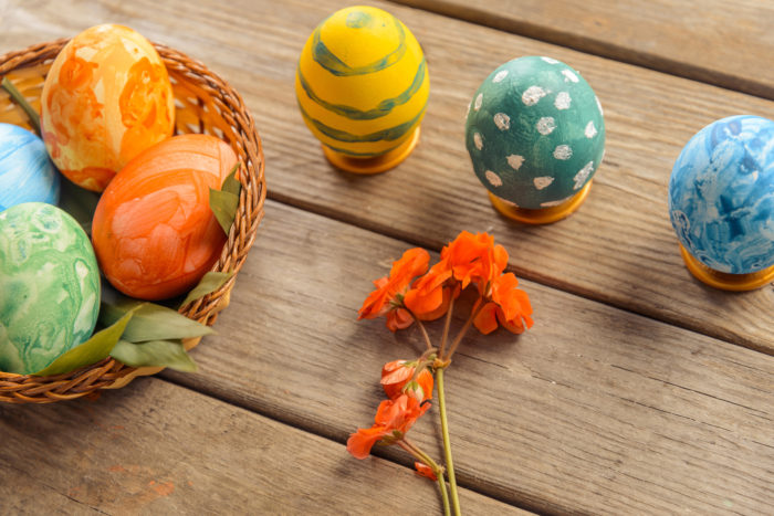 Easter colored eggs and flower on a wooden table