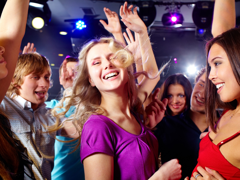 Image of happy young girls having fun at disco