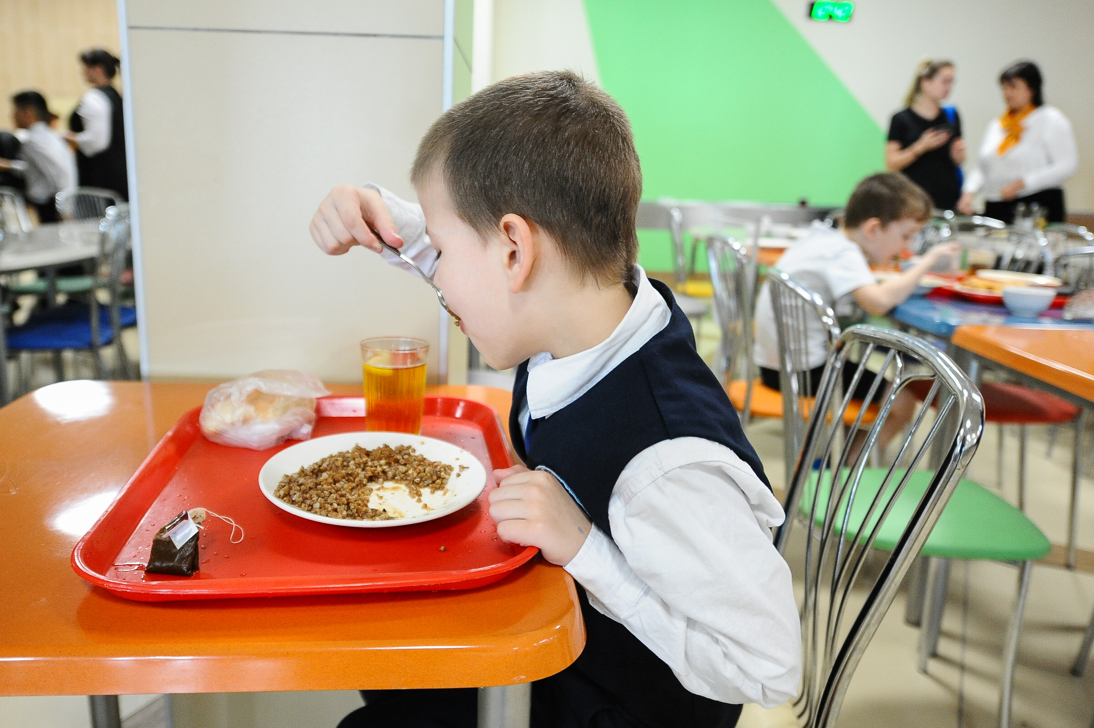 Сидит в столовой. Обед в школе. Питание в школе. Дети в столовой. Обед в школьной столовой.
