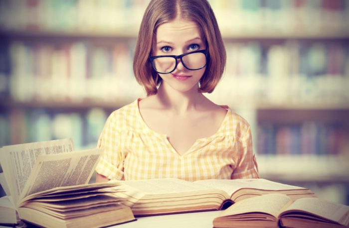 funny girl student with glasses reading books