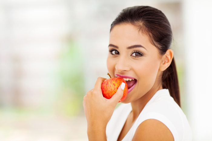 beautiful young woman eating an apple