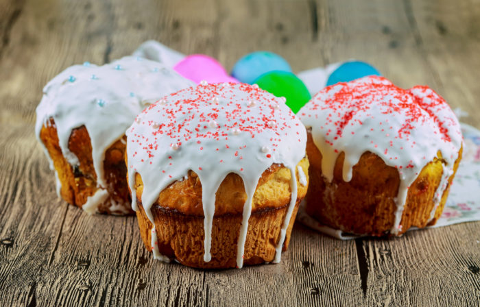 Homemade traditional easter cake kulich Ukrainian style with colored eggs on painted towel