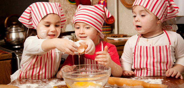 Three little chefs enjoying in the kitchen making big mess. Litt