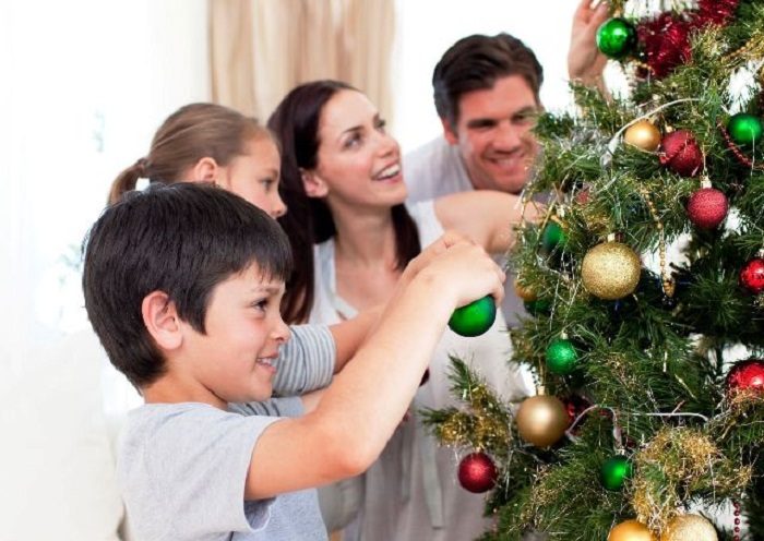 10222263 - happy family decorating a christmas tree with boubles